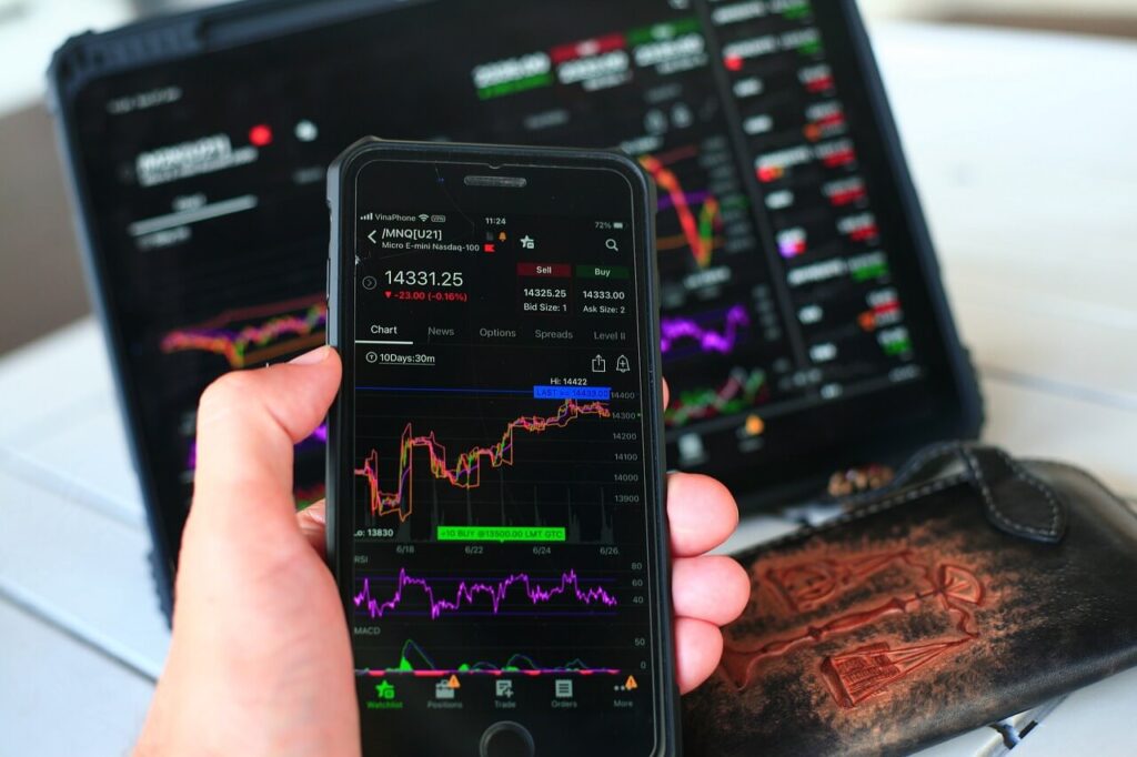 celular com gráficos financeiros, pessoa analisando finanças no app, mão segurando smartphone com tela de finanças