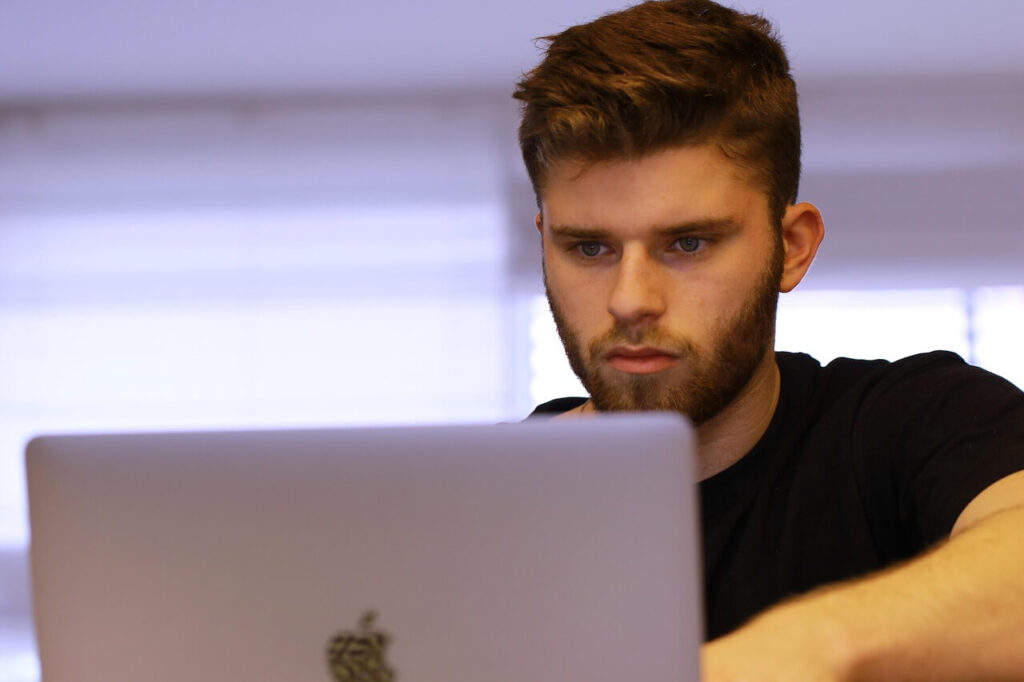 Homen aprendendo sobre educação financeira com LuanHSP no nootbook.