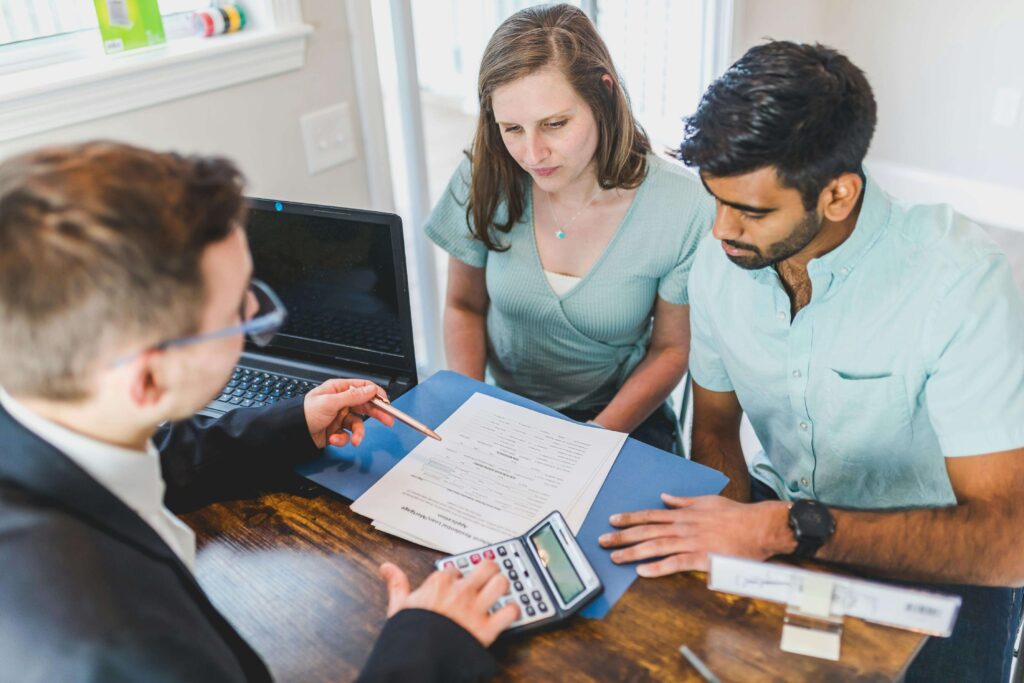 Casal de jovems conversando com o contador, planejando a aposentadoria com responsabilidade.