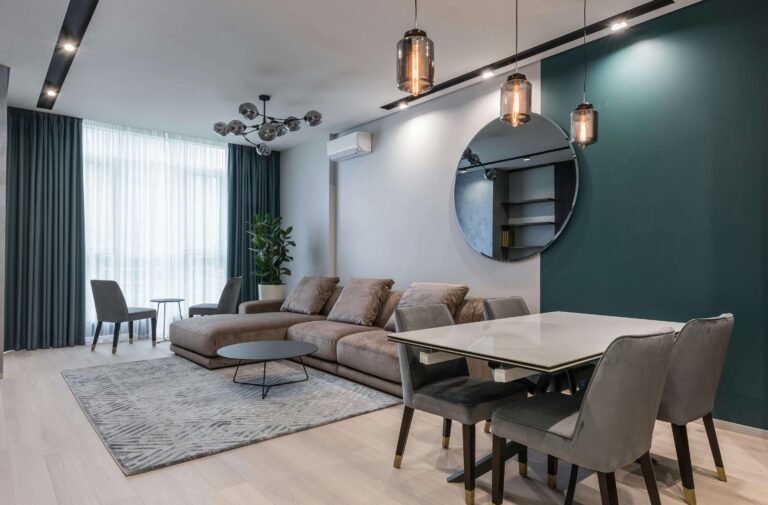 Sala de estar bem iluminada com decoração elegante e aconchegante, com plantas e detalhes estilosos, transmitindo a ideia de decoração de bom gosto acessível e sem estourar o orçamento.