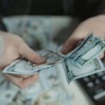 Mãos com notas de dinheiro. Simboliza planejamento e prosperidade com o novo salário mínimo.